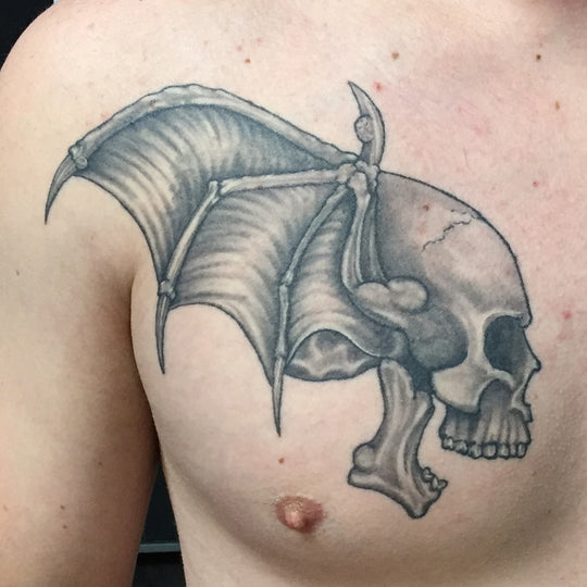 Black and grey skull and batwing tattoo