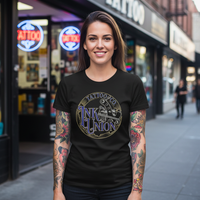 Blue Script Tee — Tattooed female model wearing black Ink Union Tattoo Co. blue script tattoo machine graphic t-shirt in front of tattoo shop storefront — alternative streetwear, tattoo artist tee, unisex graphic t-shirt, edgy cool fashion