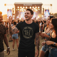 IU Gold Badge Tee — Tattooed white male model wearing black Ink Union Clothing Co. gold badge brand art unisex graphic tee laughing with friends at outdoor music festival at golden hour — alternative streetwear, tattoo artist t-shirt, unisex graphic tee, edgy cool fashion