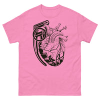 A pink t-shirt with a black grenade of sold color and line work morphing into an anatomical heart drawn using line work and hatching for shading at the top right of the image.