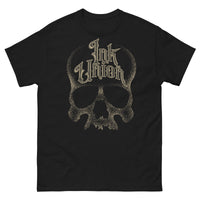 A black t-shirt with a gold dot work human skull and the words Ink Union in fancy gold and black lettering across the forehead of the skull.