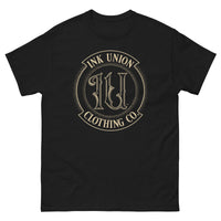 A black t-shirt adorned with the Ink Union Clothing Co gold badge logo containing fancy lettering and dot work gradients.