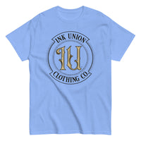A periwinkle t-shirt with the Ink Union Clothing Co Badge logo in black and gold centered on the front of the shirt.