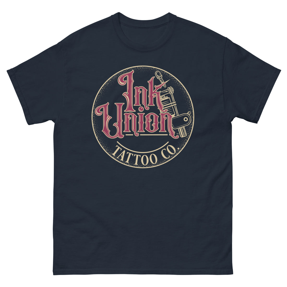 A navy blue t-shirt with a gold circle containing fancy lettering in red and gold that says Ink Union and a gold tattoo machine peeking out from behind on the right side.  There is a dot work gradient inside the circle, and the words Tattoo Co. in gold are at the bottom of the design.