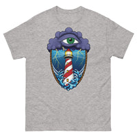 A light grey t-shirt with an old school eye of the storm tattoo design of large dark purple storm clouds at the top of the design with a green eye in the middle of the clouds.  Below the clouds is an oval shape with brown rope. Inside the rope are stormy seas and a lighthouse with lightning striking in the background.  At the bottom of the design, some of the waves are spilling out of the rope barrier. The sky and seas are hues of blue; the lighthouse is white and red striped like a barber pole.