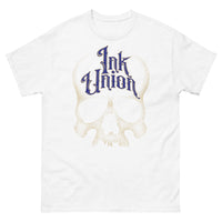 A white t-shirt adorned with a gold dot work human skull  and the words Ink Union in fancy gold and blue lettering across the forehead of the skull.