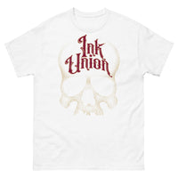 A white t-shirt adorned with a gold dot work human skull  and the words Ink Union in fancy gold and red lettering across the forehead of the skull.
