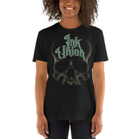 An attractive woman wearing a black t-shirt  adorned with a gold dot work human skull and the words Ink Union in fancy gold and green lettering across the forehead of the skull.