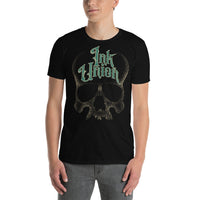 An attractive man wearing a black t-shirt  adorned with a gold dot work human skull and the words Ink Union in fancy gold and green lettering across the forehead of the skull.
