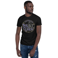An attractive man wearing a black t-shirt adorned with the Ink Union Tattoo Co. blue and gold with a silver tattoo machine logo.