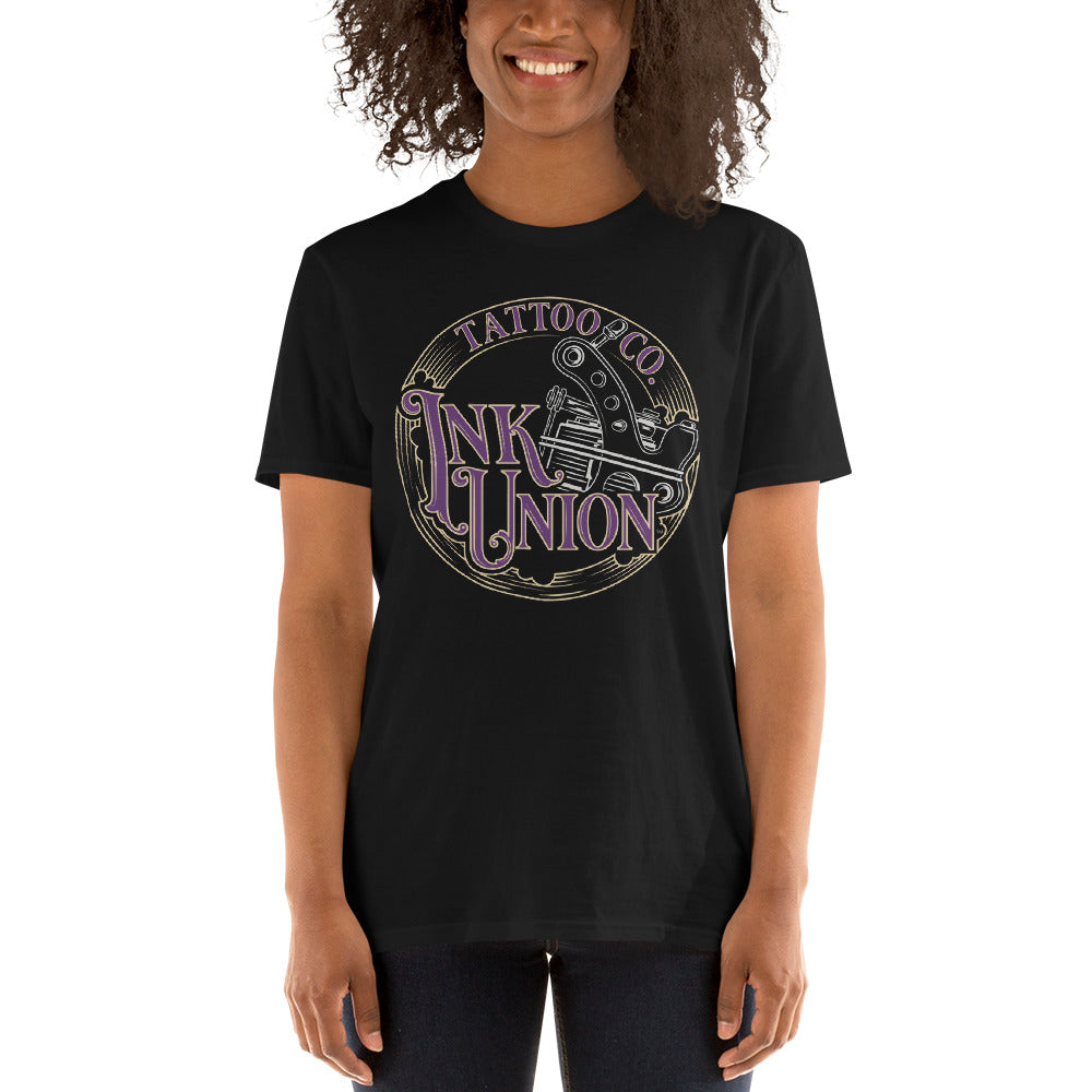 An attractive woman wearing a black t-shirt adorned with the Ink Union Tattoo Co. purple and gold with a silver tattoo machine logo.