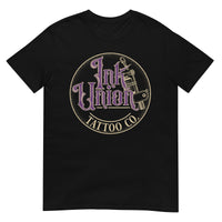 A black t-shirt with a gold circle containing fancy lettering in purple and gold that says Ink Union and a gold tattoo machine peeking out from behind on the right side.  There is a dot work gradient inside the circle, and the words Tattoo Co. in gold are at the bottom of the design.