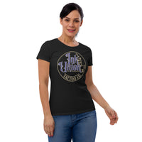 An attractive woman wearing a black t-shirt with a gold circle containing fancy lettering in blue and gold that says Ink Union and a gold tattoo machine peeking out from behind on the right side.  There is a dot work gradient inside the circle, and the words Tattoo Co. in gold are at the bottom of the design.