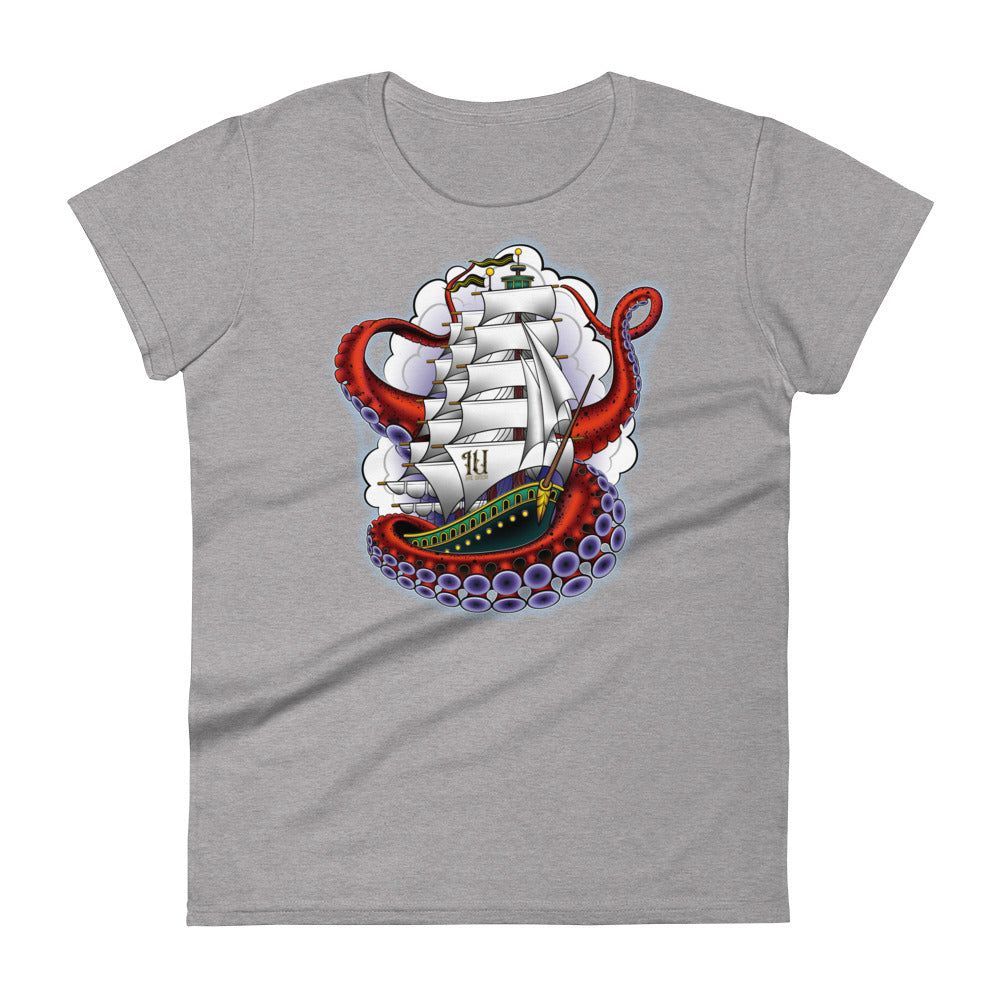 A light grey t-shirt with an old-school clipper ship tattoo design in green and brown with white sails surrounded by octopus tentacles in shades of red with purple tentacles. Behind the ship are purple-tinged clouds.