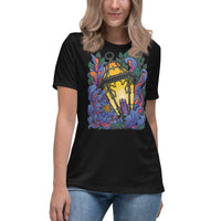 An attractive woman wearing a black t-shirt with Chrysanthemum petals in blues and reds wrapped around an antique lantern lit by a candle. Dark green leaves border the image at the top and bottom behind the flower petals.