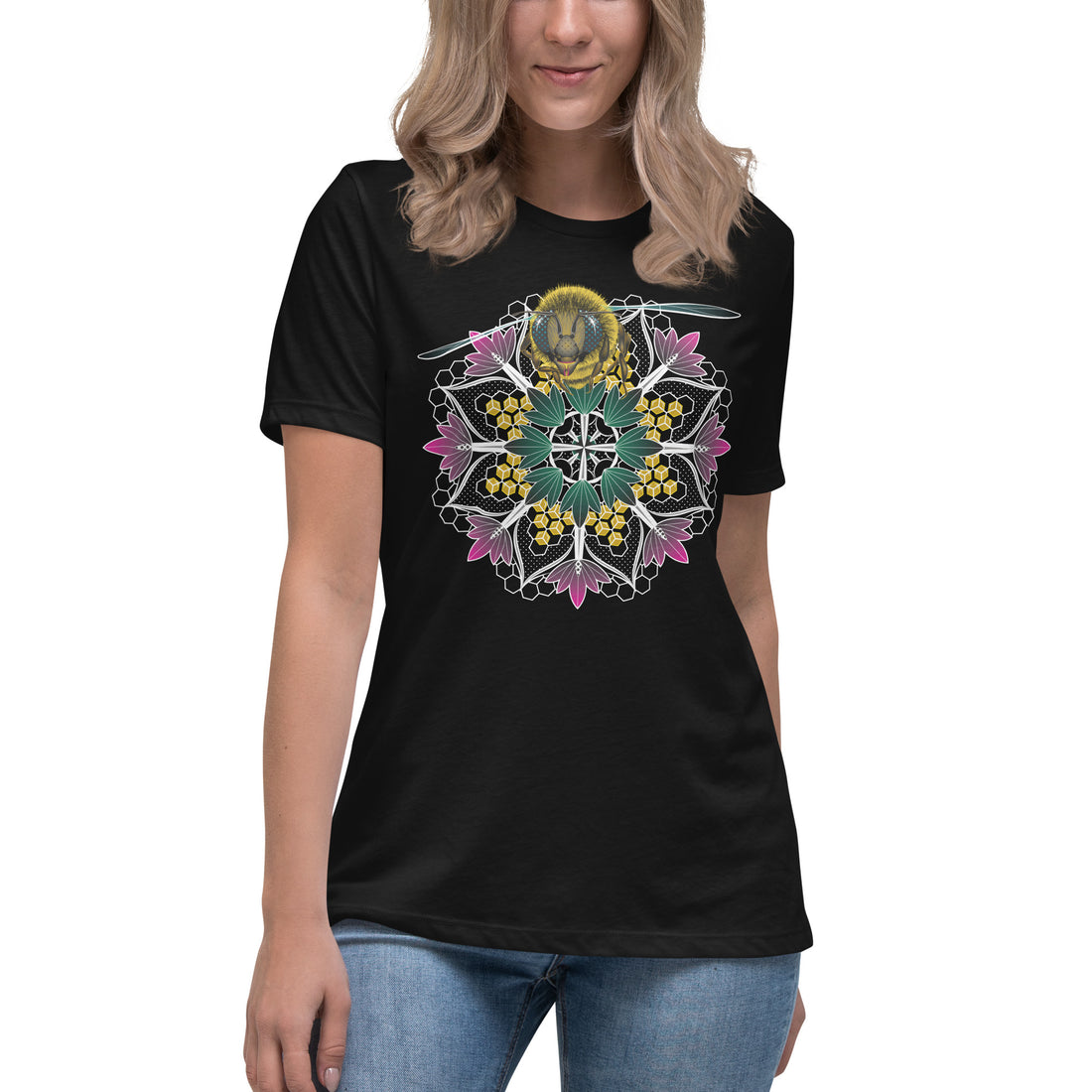 A woman wearing a black t-shirt with a mandala containing pink lotus flowers and honeycomb designs and a life-like honeybee flying toward you at the top of the mandala.