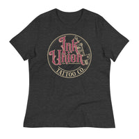 A dark grey t-shirt with a gold circle containing fancy lettering in red and gold that says Ink Union and a gold tattoo machine peeking out from behind on the right side. There is a dot work gradient inside the circle, and the words Tattoo Co. in gold are at the bottom of the design.