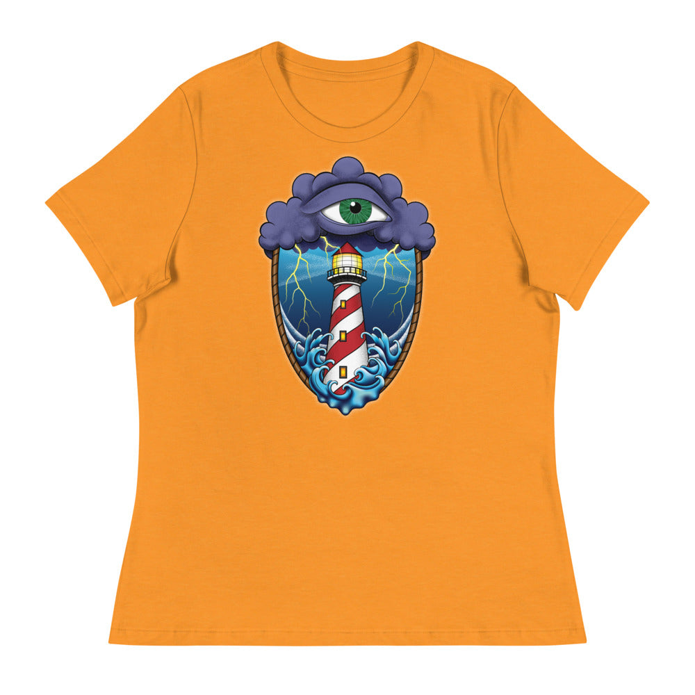 A yellow gold t-shirt with an old school eye of the storm tattoo design of large dark purple storm clouds at the top of the design with a green eye in the middle of the clouds.  Below the clouds is an oval shape with brown rope. Inside the rope are stormy seas and lightning striking at a lighthouse that is white and red striped like a barber pole.