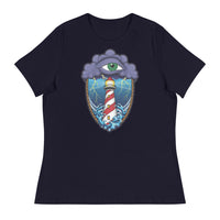 A navy blue t-shirt with an old school eye of the storm tattoo design of large dark purple storm clouds at the top of the design with a green eye in the middle of the clouds.  Below the clouds is an oval shape with brown rope. Inside the rope are stormy seas and lightning striking at a lighthouse that is white and red striped like a barber pole.