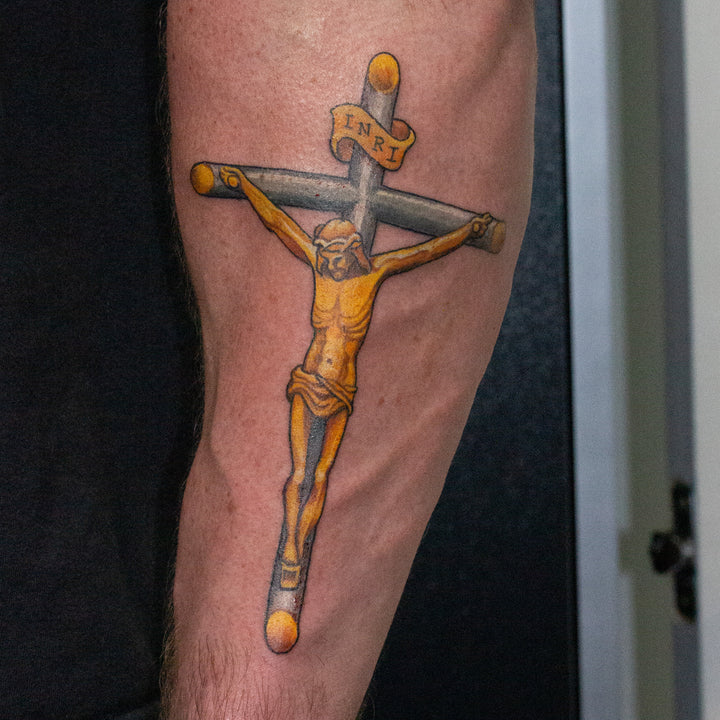 Gold and silver tattoo of a crucifix.