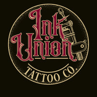 A black background with a gold circle containing fancy lettering in red and gold that says Ink Union and a gold tattoo machine peeking out from behind on the right side.  There is a dot work gradient inside the circle, and the words Tattoo Co. in gold are at the bottom of the design.