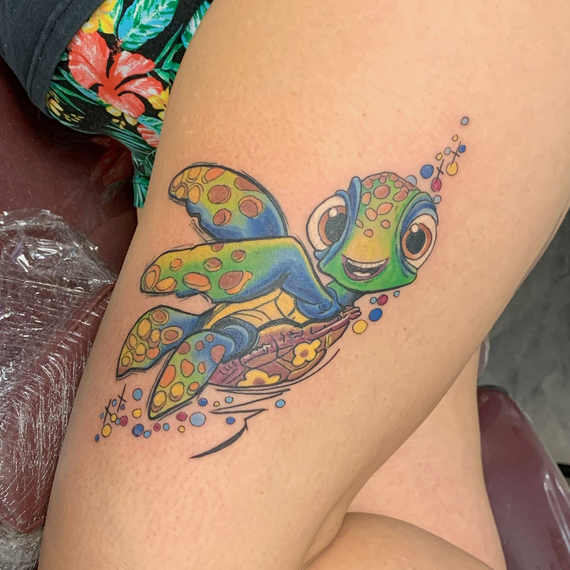 color thigh tattoo of the character squirt, the turtle, from the finding nemo movie