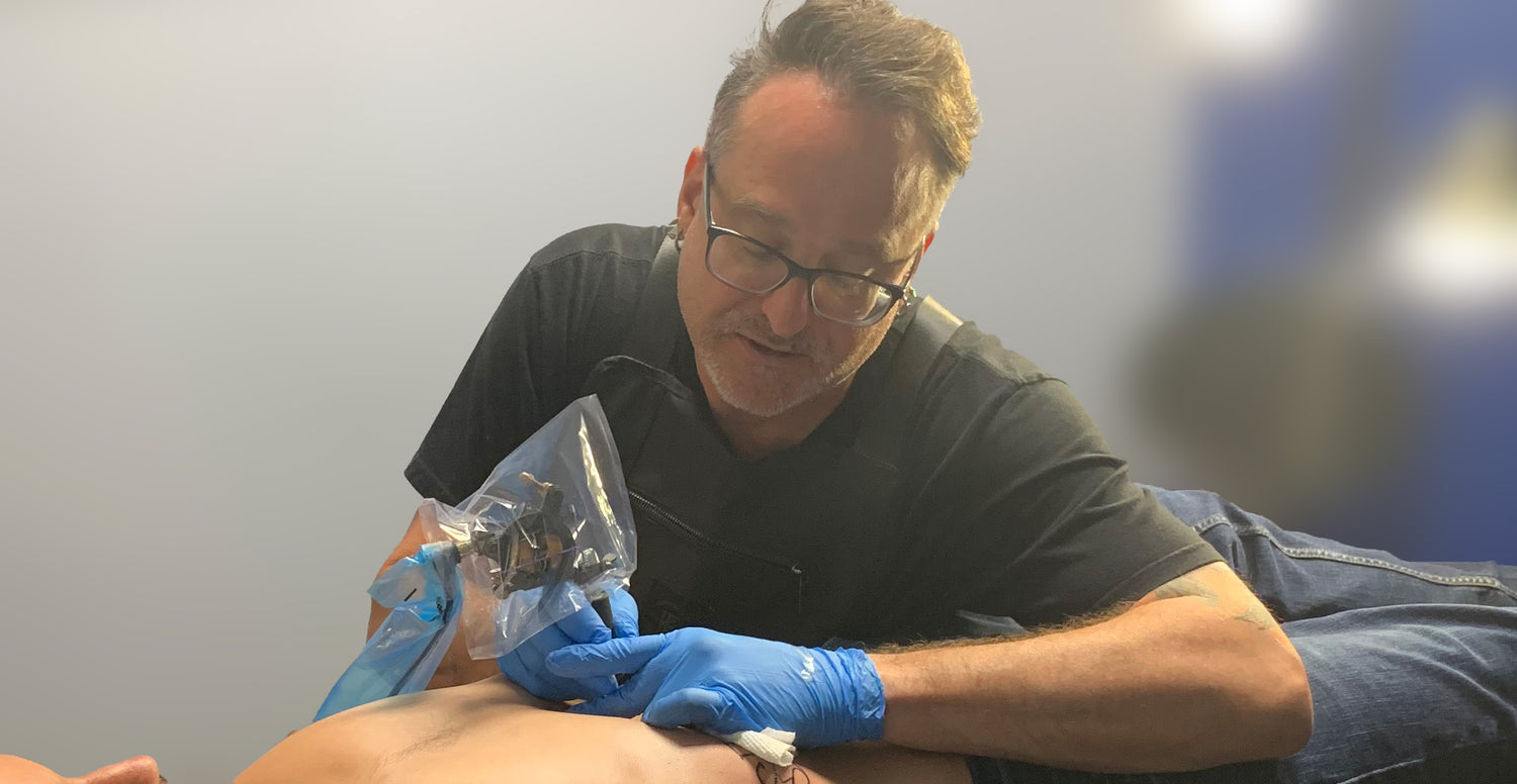 Artist Shawn Pierce tattooing a mans Stomach