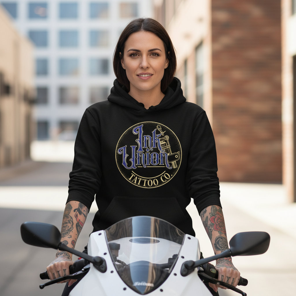 Blue & Gold Flash Art Hoodie — Tattooed female model wearing black Ink Union Tattoo Co. blue and gold flash art tattoo machine hoodie sitting on white sport motorcycle — alternative streetwear, tattoo artist sweatshirt, unisex heavy blend hoodie, edgy cool fashion