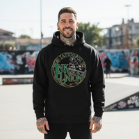 Green Script Hoodie — Urban Plaza Tattooed male model wearing black Ink Union Tattoo Co. green script tattoo machine graphic hoodie at urban plaza — alternative streetwear, tattoo artist sweatshirt, unisex heavy blend hoodie, edgy cool fashion