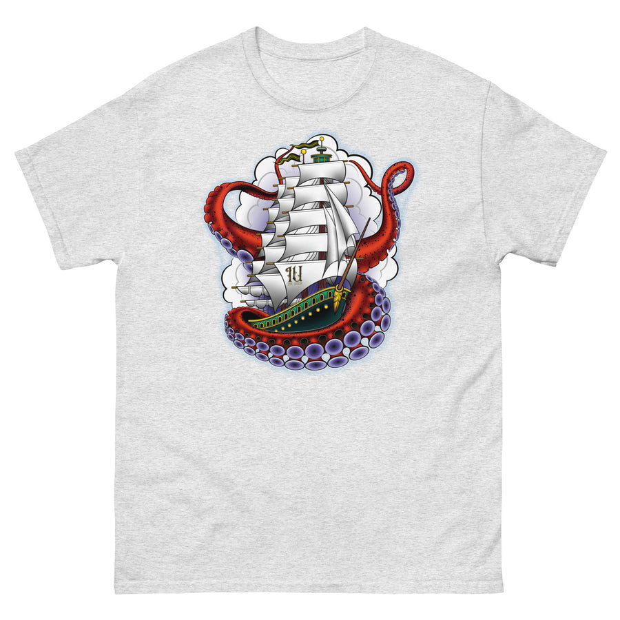 A very light grey t-shirt with an old-school clipper ship tattoo design in green and brown with white sails surrounded by octopus tentacles in shades of red with purple tentacles. Behind the ship are purple-tinged clouds.