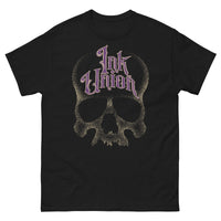 A black t-shirt adorned with a gold dot work human skull  and the words Ink Union in fancy gold and purple lettering across the forehead of the skull.