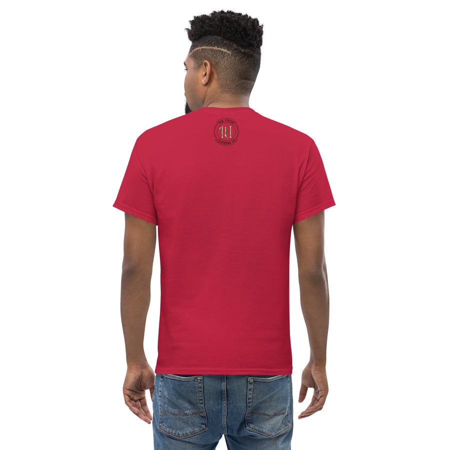 The back view of an attractive man wearing a red t-shirt with a small gold and black Ink Union badge Logo centered just under the neckline.