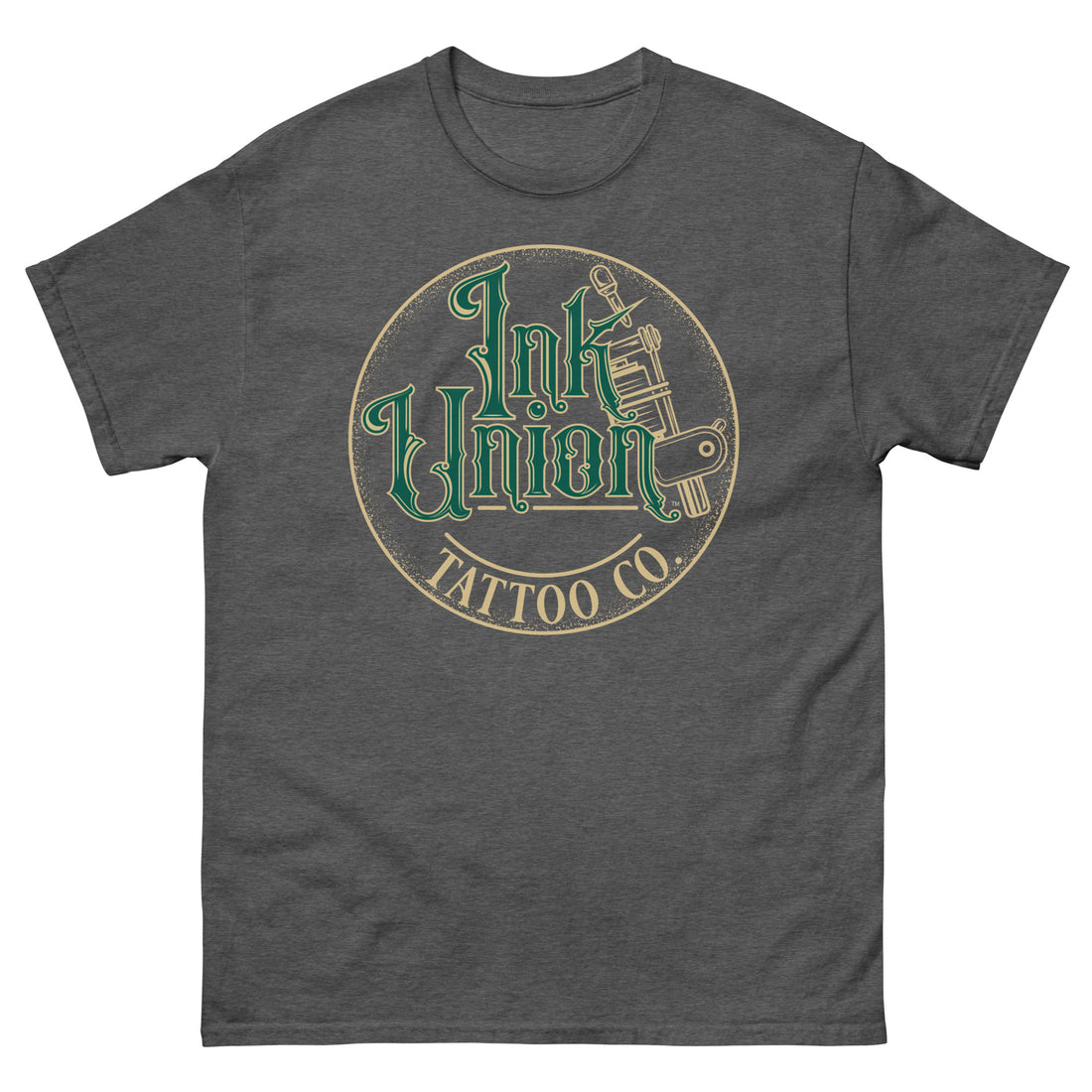 A dark grey t-shirt with a gold circle containing fancy lettering in green and gold that says Ink Union and a gold tattoo machine peeking out from behind on the right side. There is a dot work gradient inside the circle, and the words Tattoo Co. in gold are at the bottom of the design.