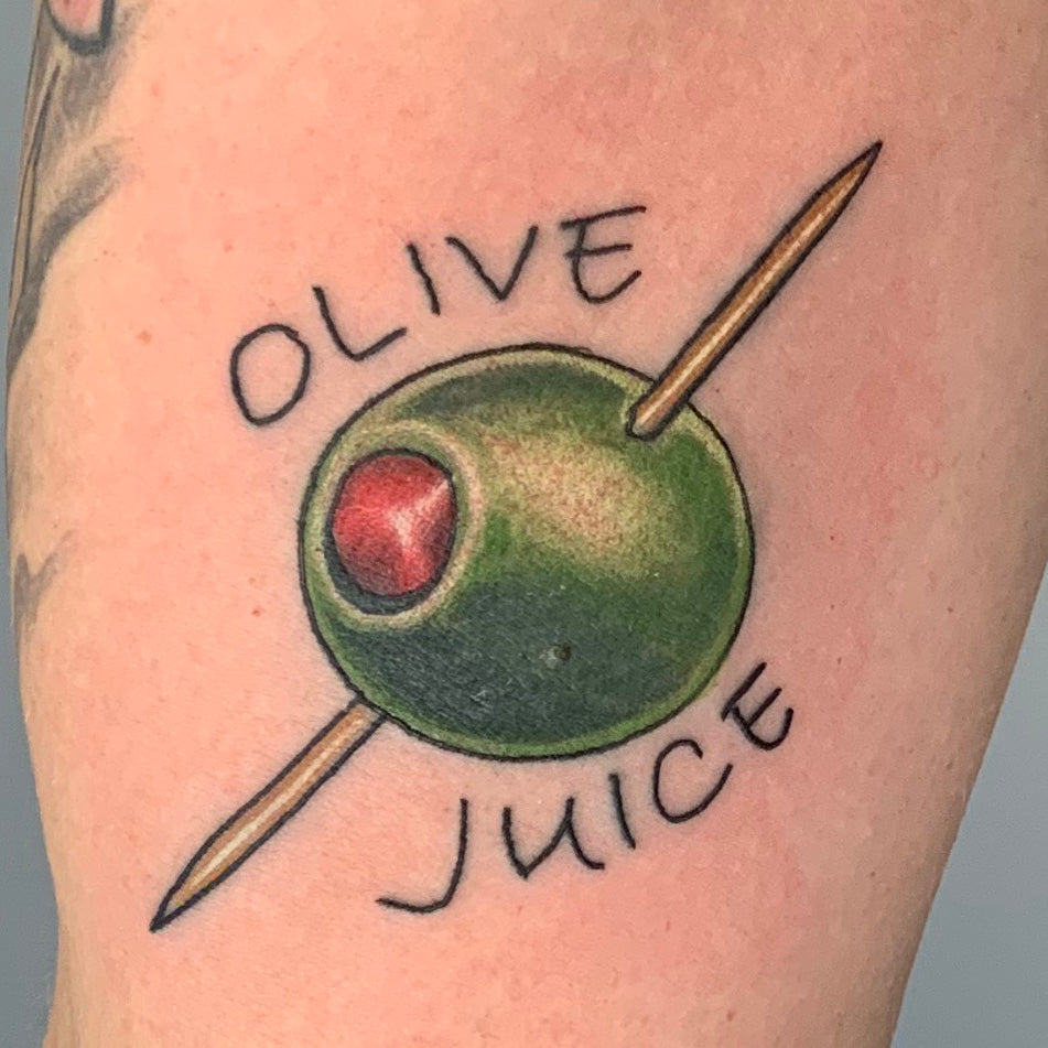 color tattoo of an olive on a tooth pick with the words olive juice