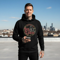 Smiling tattooed male model wearing black Ink Union Tattoo Co. red script tattoo machine graphic hoodie on sunny urban rooftop — alternative streetwear, tattoo artist sweatshirt, unisex heavy blend hoodie, edgy cool fashion
