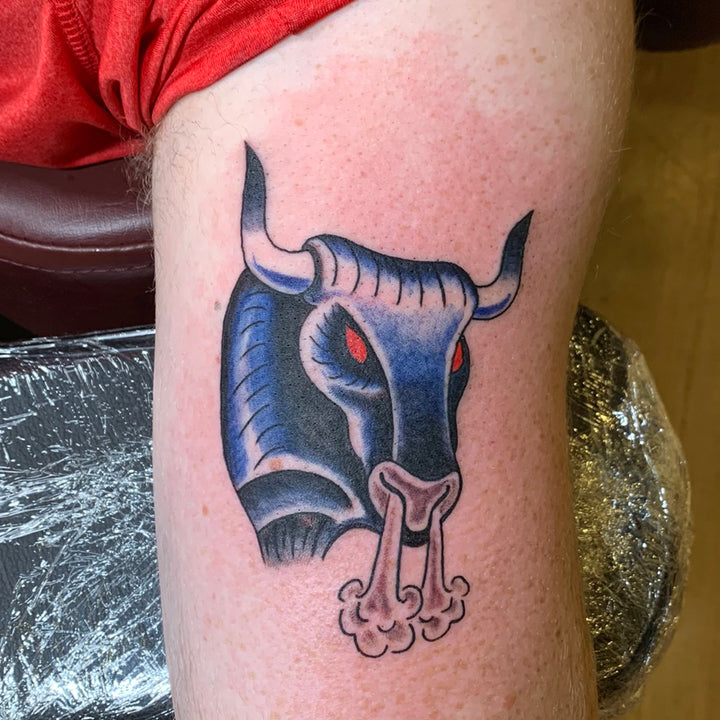 American traditional style taurus the bull in blue with red eyes