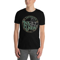 An attractive man wearing a black t-shirt adorned with the Ink Union Tattoo Co. green and gold with a silver tattoo machine logo.