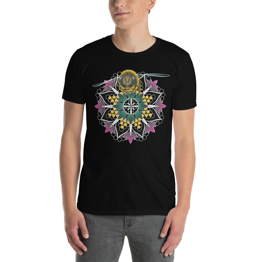 A man wearing a black t-shirt with a mandala containing pink lotus flowers and honeycomb designs and a life-like honeybee flying toward you at the top of the mandala.