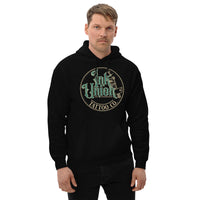 An attractive man wearing a black hoodie with a gold circle containing fancy lettering in green and gold that says Ink Union and a gold tattoo machine peeking out from behind on the right side.  There is a dot work gradient inside the circle, and the words Tattoo Co. in gold are at the bottom of the design.