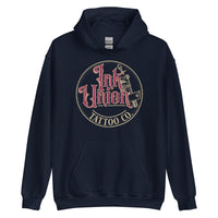 A navy blue hoodie with a gold circle containing fancy lettering in red and gold that says Ink Union and a gold tattoo machine peeking out from behind on the right side.  There is a dot work gradient inside the circle, and the words Tattoo Co. in gold are at the bottom of the design.