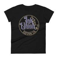 A black t-shirt with a gold circle containing fancy lettering in blue and gold that says Ink Union and a gold tattoo machine peeking out from behind on the right side.  There is a dot work gradient inside the circle, and the words Tattoo Co. in gold are at the bottom of the design.