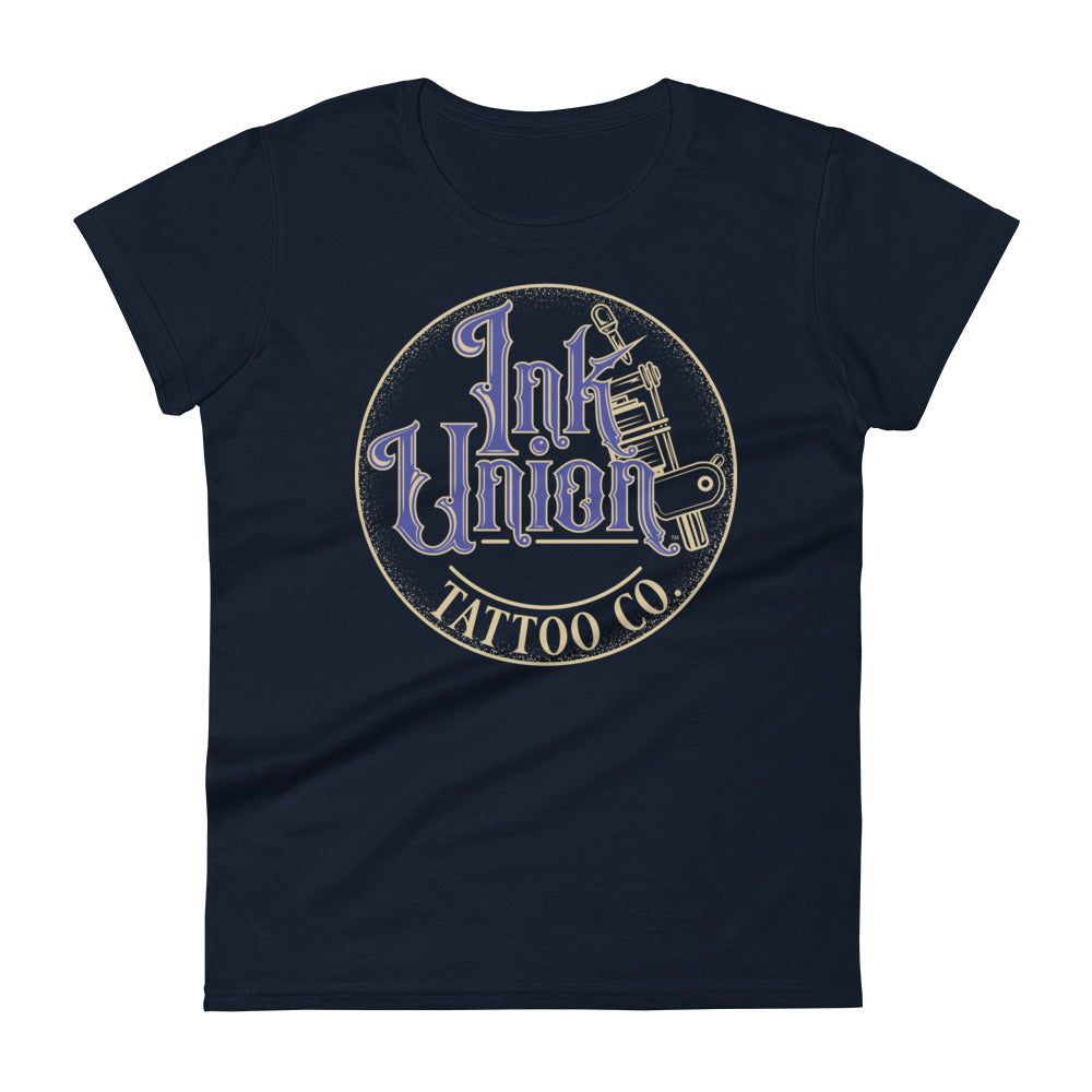 A navy blue t-shirt with a gold circle containing fancy lettering in blue and gold that says Ink Union and a gold tattoo machine peeking out from behind on the right side.  There is a dot work gradient inside the circle, and the words Tattoo Co. in gold are at the bottom of the design.