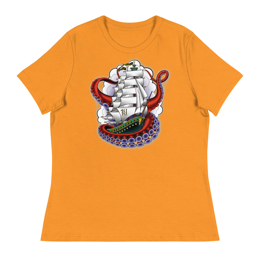 An orange t-shirt with an old-school clipper ship tattoo design in green and brown with white sails surrounded by octopus tentacles in shades of red with purple tentacles. Behind the ship are purple-tinged clouds.