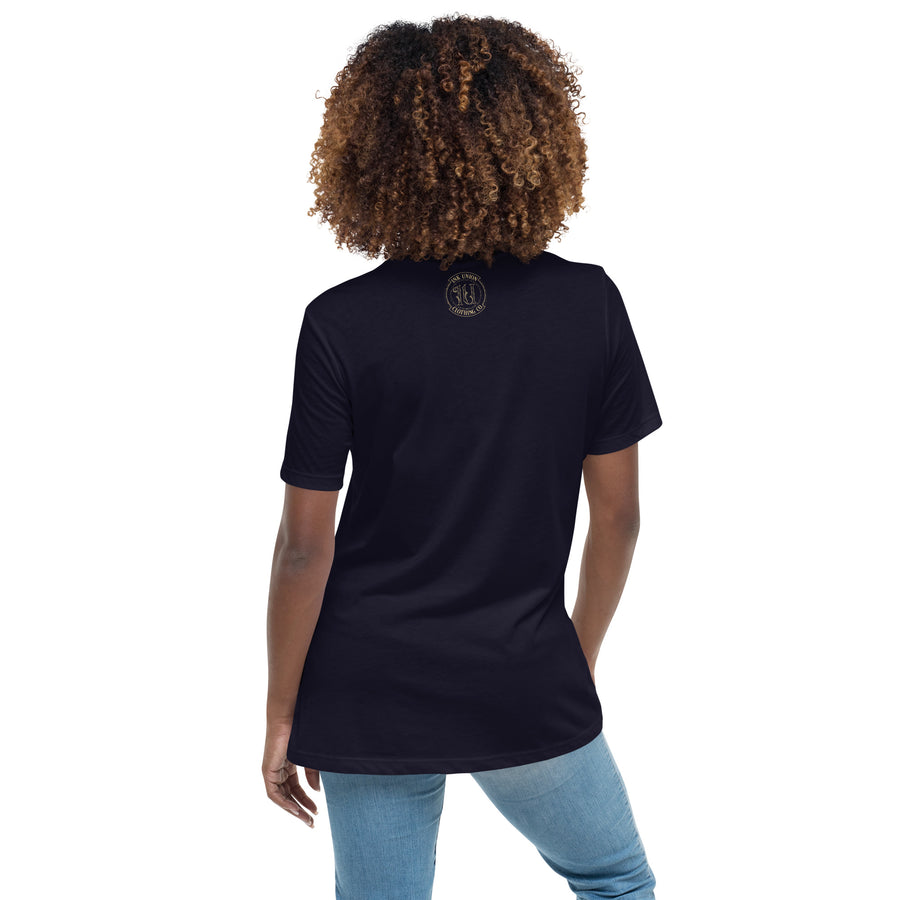 The back view of an attractive woman wearing a navy blue t-shirt with a small gold Ink Union Badge Logo centered just under the neckline.