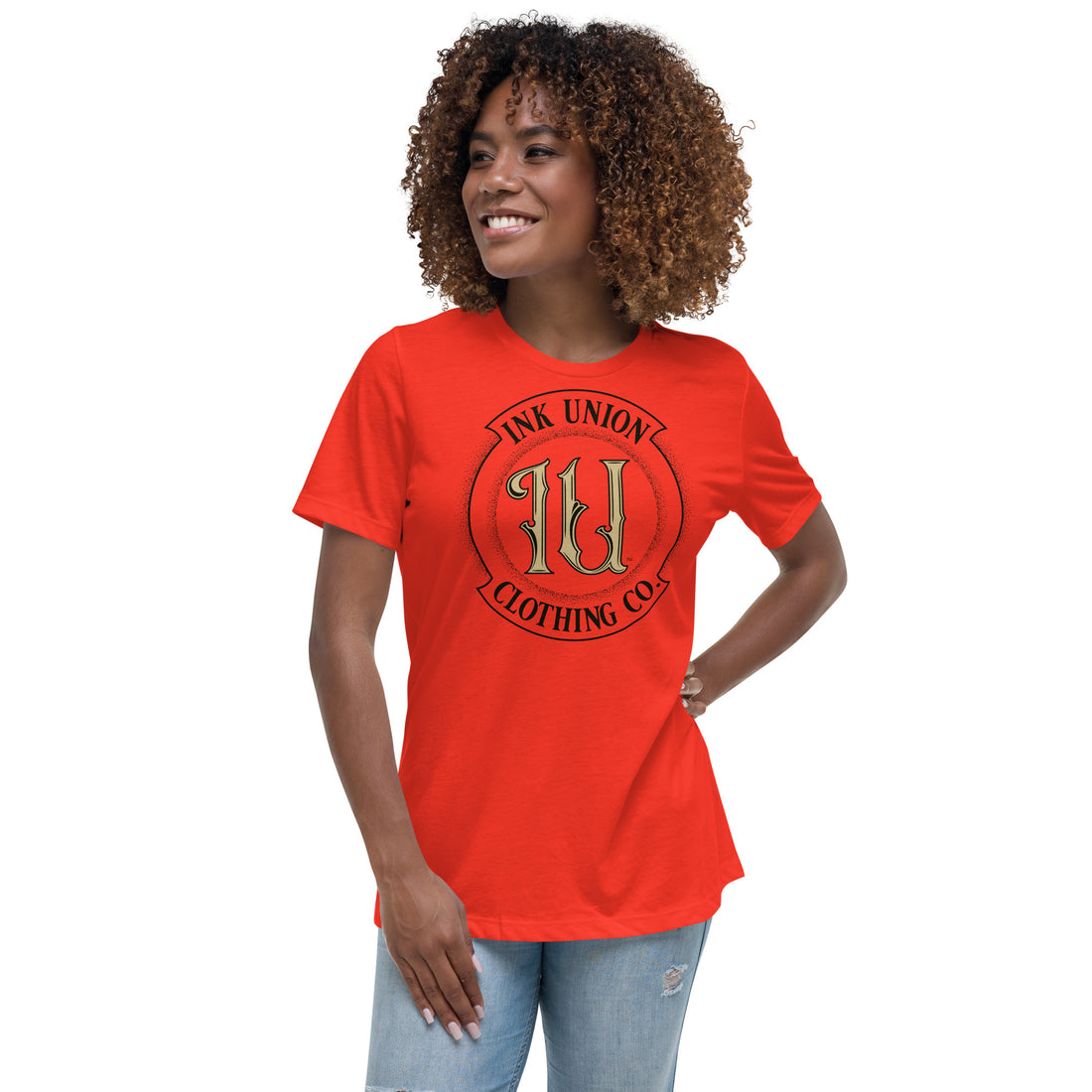 An attractive woman wearing a poppy red t-shirt with a large gold and black Ink Union badge Logo centered on the chest.