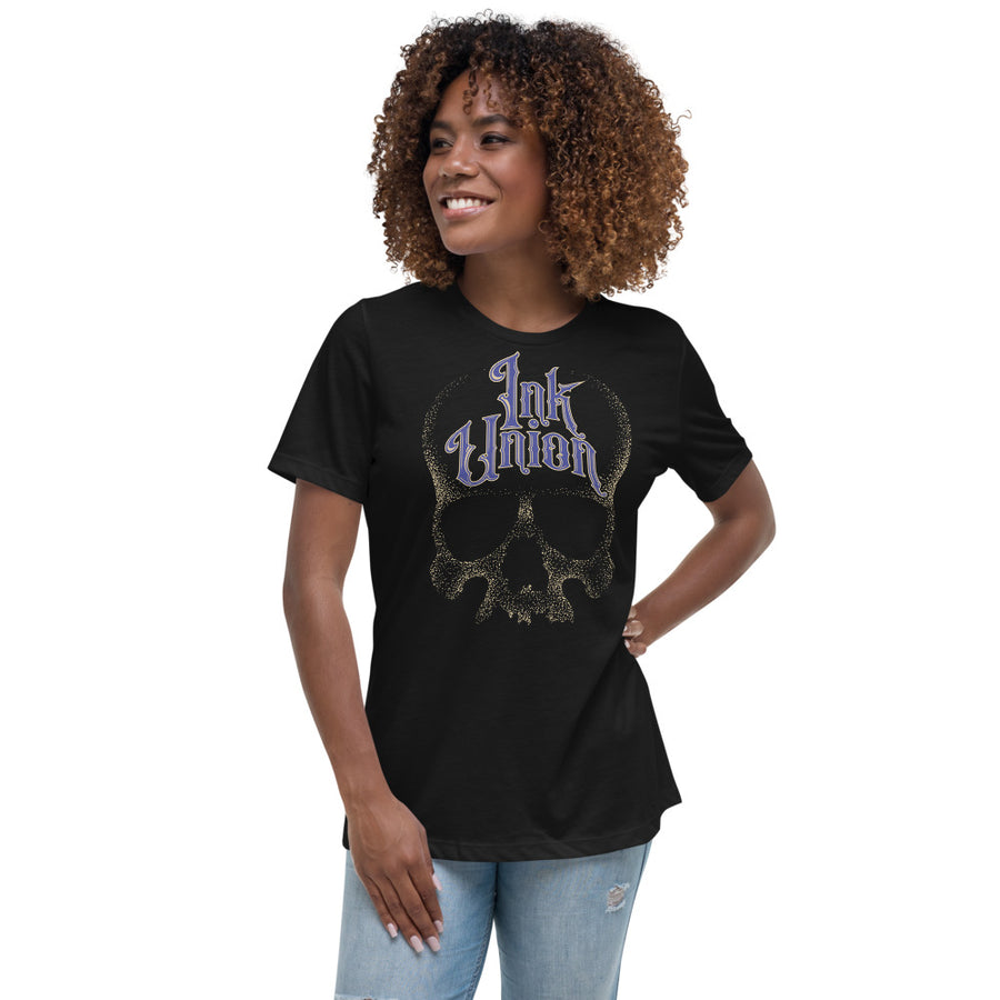 woman wearing an Ink Union Clothing Co. women's relaxed fit black t-shirt  featuring a large dot work gold skull centered on the shirt and Ink Union in large fancy gold and blue script across the forehead of the skull